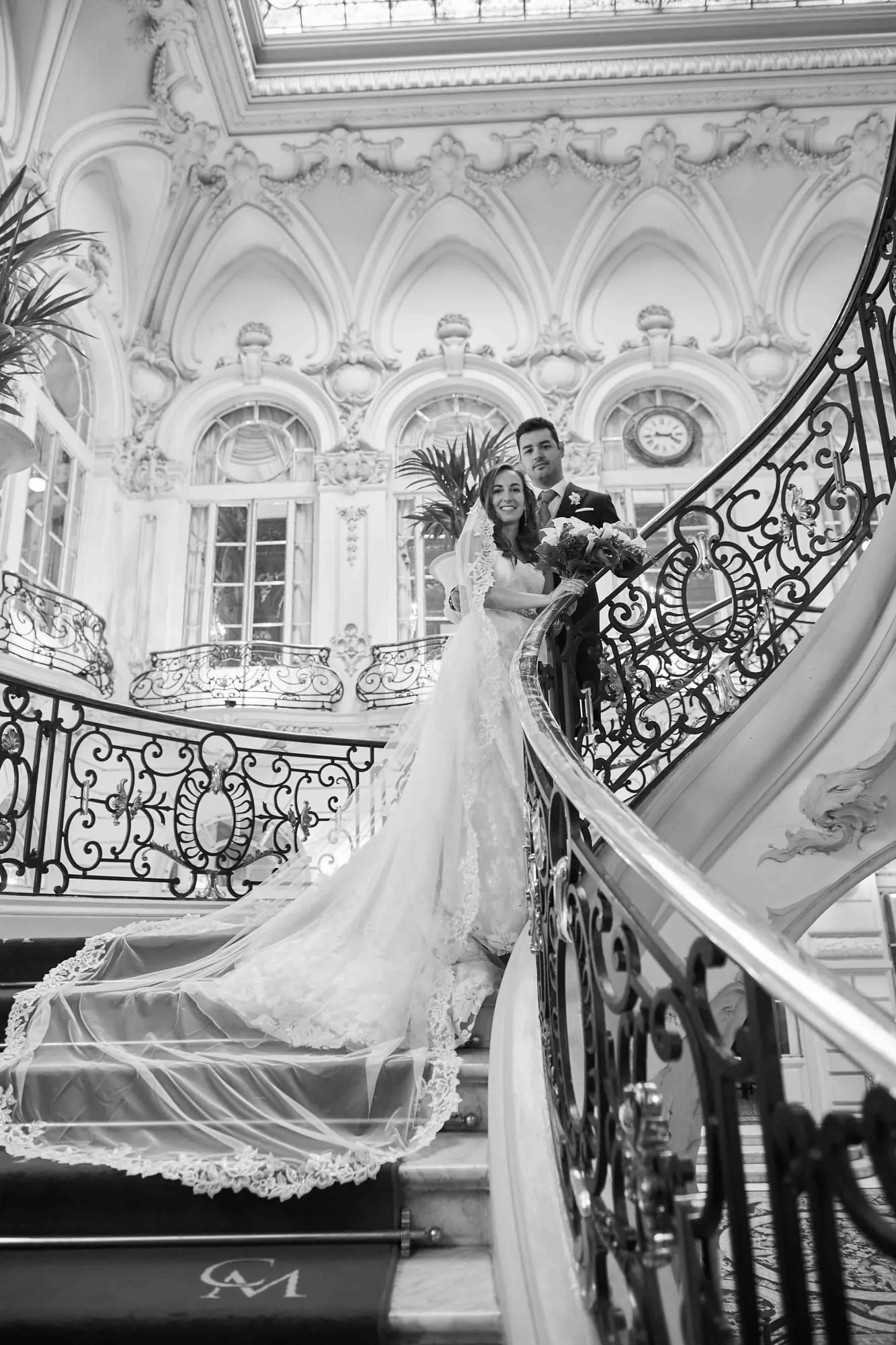 Couple on the imperial staircase of a Madrid palace, in black and white