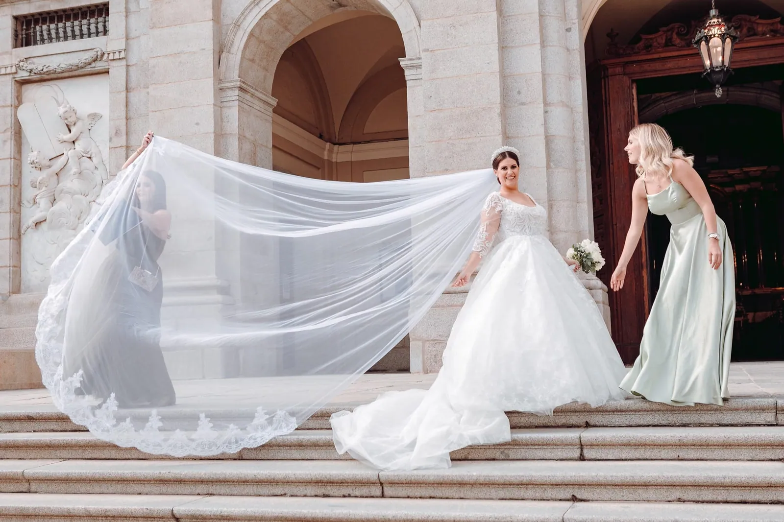 Bride with a long veil on a flight of steps